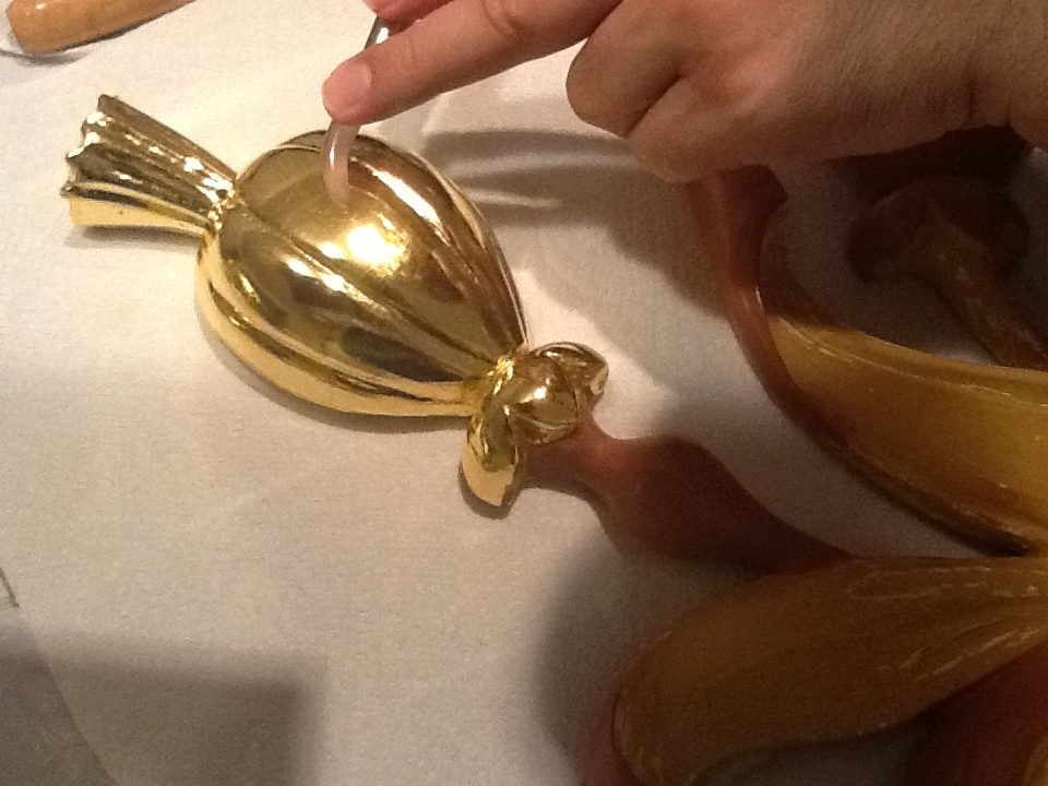 Wooden ornament during gilding restoration and burnishing